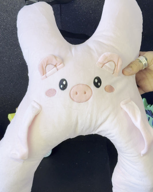Cojín de viaje Sleepy Piggy colocado en el asiento del coche